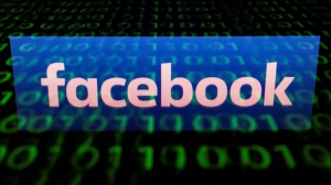  Logotipo de Facebook reflejado en una pantalla con información binaria. LIONEL BONAVENTURE AFP