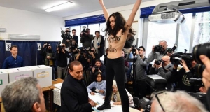 Una activista de Femen sin camiseta interrumpe a Berlusconi en su votación
