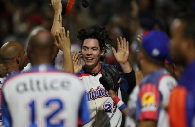 Peter O’Brien, al fondo, celebra con sus compañeros tras anotar una carrera en el partido ganado por los duartianos, en San Juan, Puerto Rico.